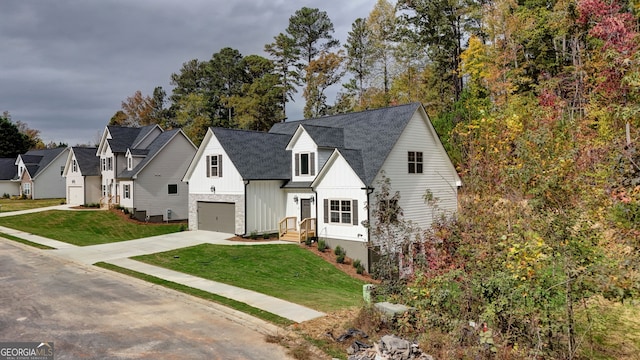 modern inspired farmhouse featuring a garage and a front yard