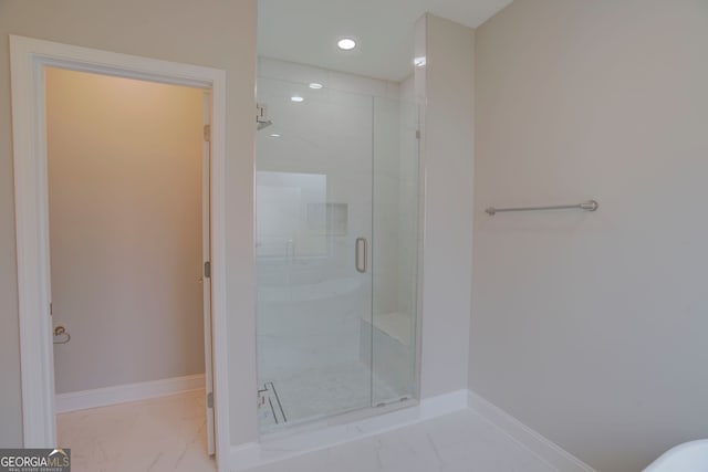 bathroom featuring a shower with door