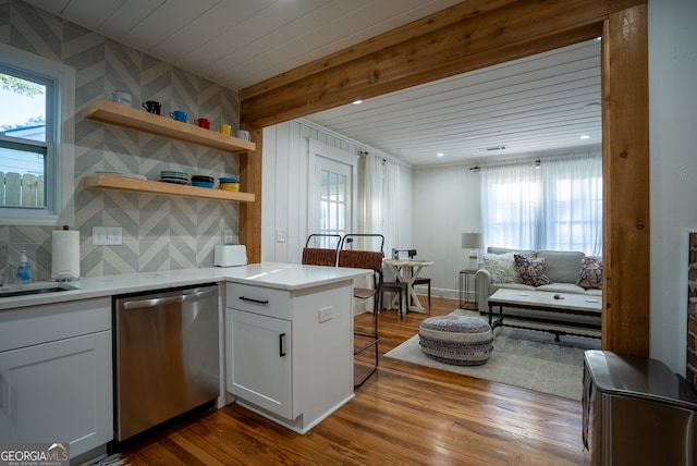 kitchen featuring dark hardwood / wood-style flooring, wood ceiling, dishwasher, kitchen peninsula, and white cabinets