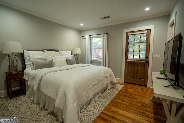 bedroom with wood-type flooring and ornamental molding