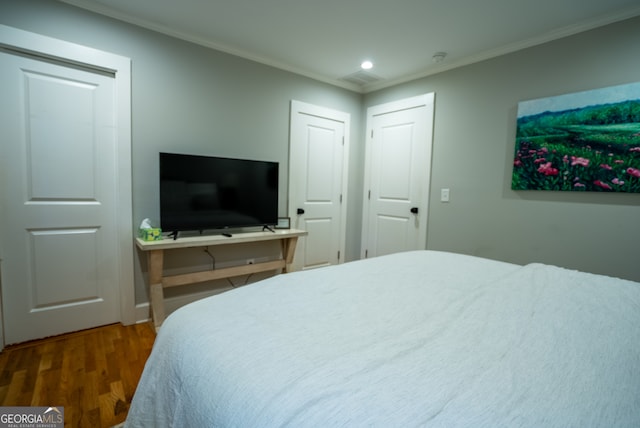 bedroom featuring dark wood-type flooring and crown molding