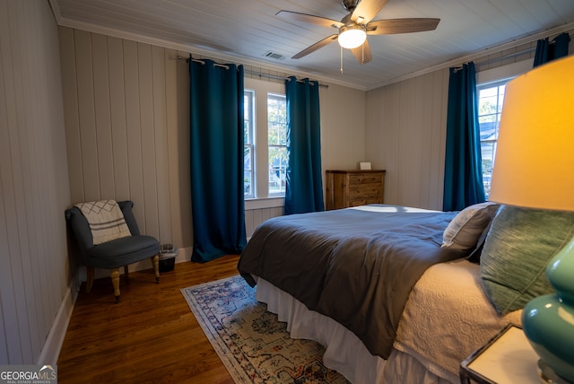 bedroom with crown molding, dark wood-type flooring, multiple windows, and ceiling fan