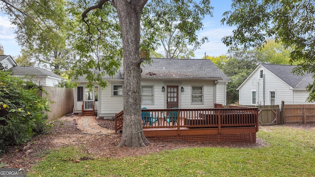 back of house featuring a lawn and a wooden deck