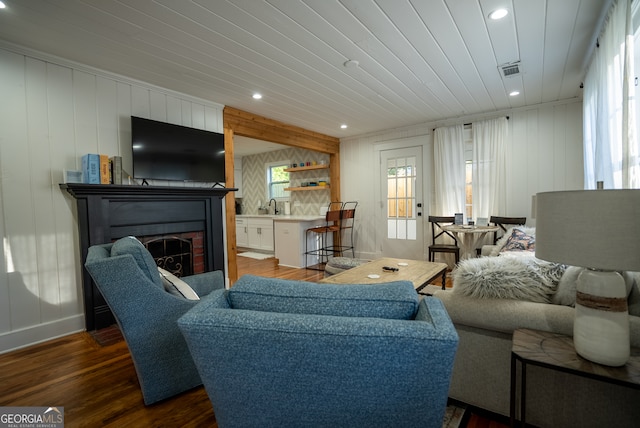 living room featuring dark hardwood / wood-style flooring, a wealth of natural light, and sink