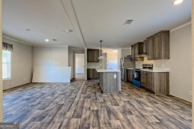 kitchen with appliances with stainless steel finishes, pendant lighting, a kitchen island with sink, crown molding, and dark wood-type flooring