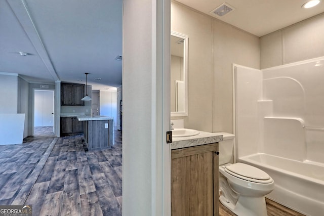 full bathroom with hardwood / wood-style flooring, vanity, toilet, and shower / bath combination