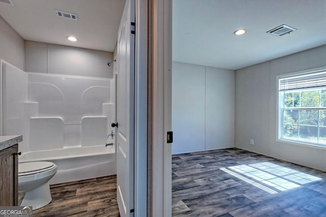 full bathroom featuring vanity, shower / bathing tub combination, hardwood / wood-style flooring, and toilet