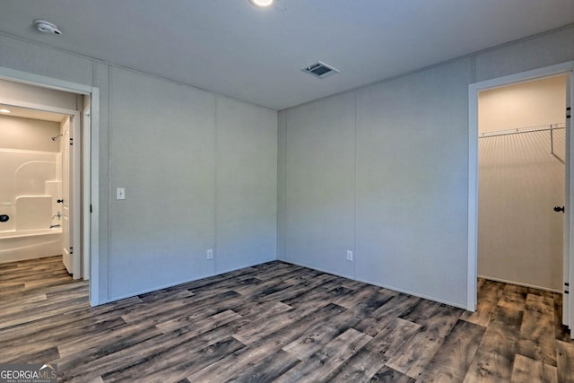 unfurnished bedroom with dark wood-type flooring and a closet