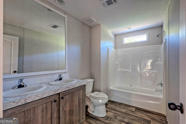 full bathroom featuring shower / bathing tub combination, vanity, hardwood / wood-style flooring, and toilet