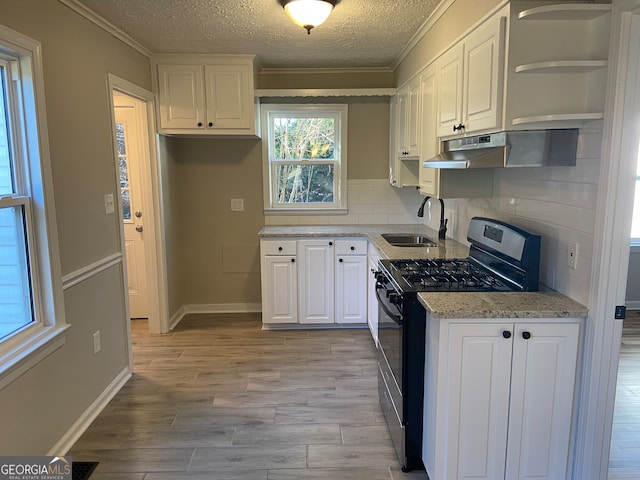 kitchen featuring white cabinets, stainless steel range with gas stovetop, a textured ceiling, and sink