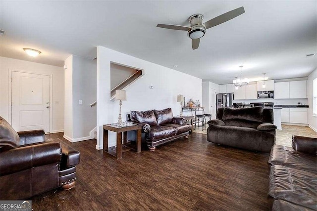 living room with ceiling fan with notable chandelier and wood-type flooring