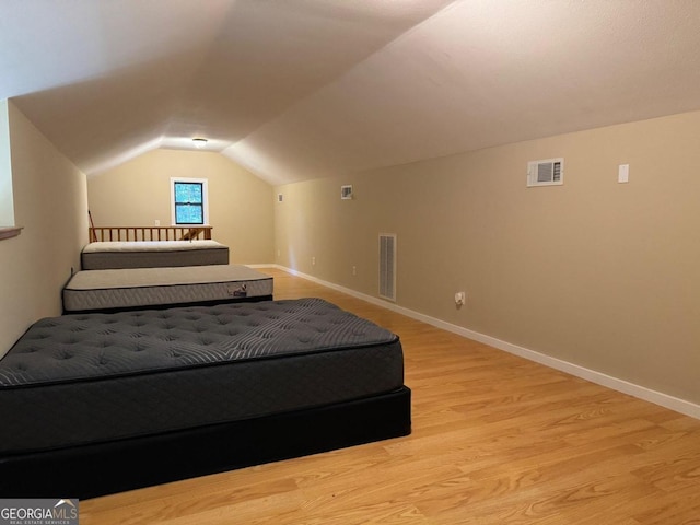 bedroom featuring light wood-type flooring and lofted ceiling