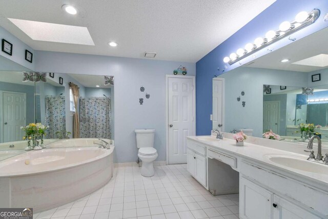 bathroom with vanity, a tub, tile patterned floors, and a skylight