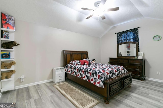 bedroom with light hardwood / wood-style floors, lofted ceiling, and ceiling fan