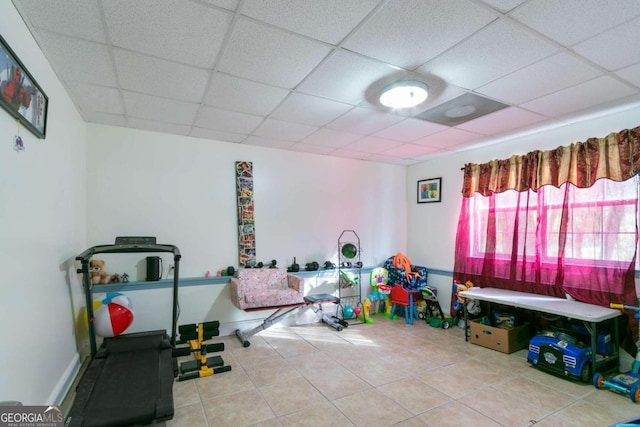 workout room featuring a drop ceiling and tile patterned floors