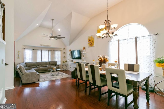 dining space featuring high vaulted ceiling, ceiling fan with notable chandelier, and dark hardwood / wood-style flooring