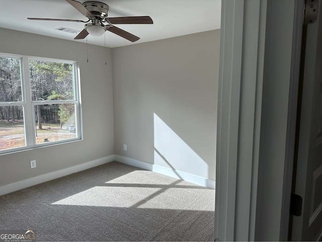 empty room with carpet floors, visible vents, and baseboards