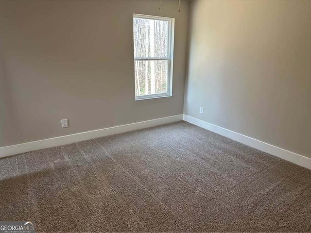 carpeted spare room with baseboards