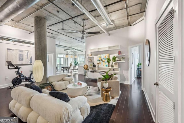 living room with dark hardwood / wood-style floors, ceiling fan, and a high ceiling