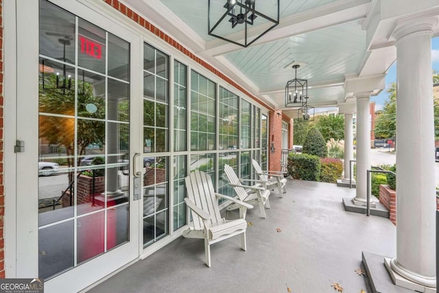 exterior space featuring a chandelier and ornate columns