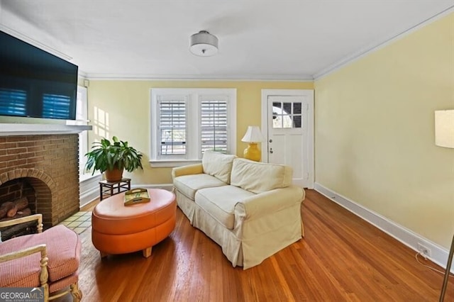 living room featuring hardwood / wood-style floors, ornamental molding, and a brick fireplace