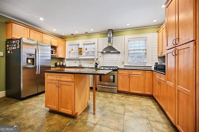 kitchen with a kitchen island, appliances with stainless steel finishes, a breakfast bar, sink, and wall chimney range hood