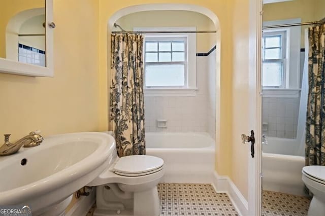 full bathroom with sink, shower / tub combo with curtain, and toilet