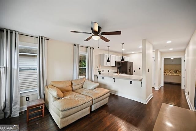 living room with ceiling fan and dark hardwood / wood-style floors