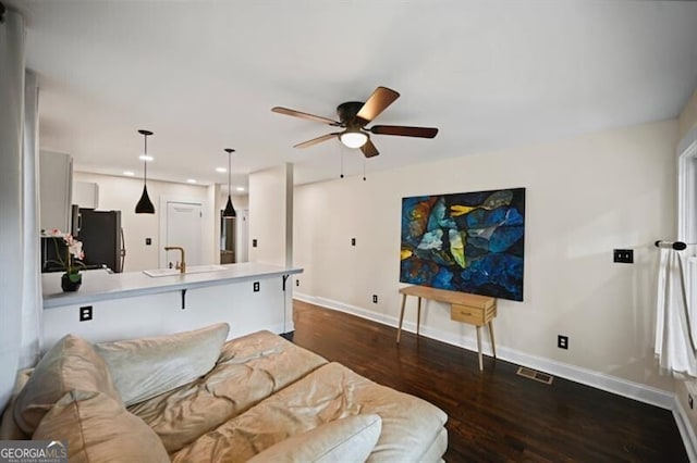 living room featuring dark hardwood / wood-style floors, sink, and ceiling fan