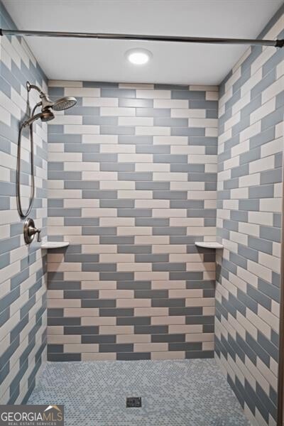 interior details featuring tiled shower