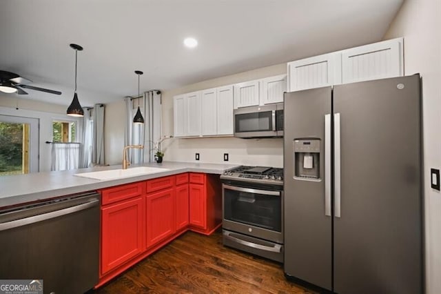 kitchen with sink, white cabinetry, dark hardwood / wood-style floors, pendant lighting, and stainless steel appliances