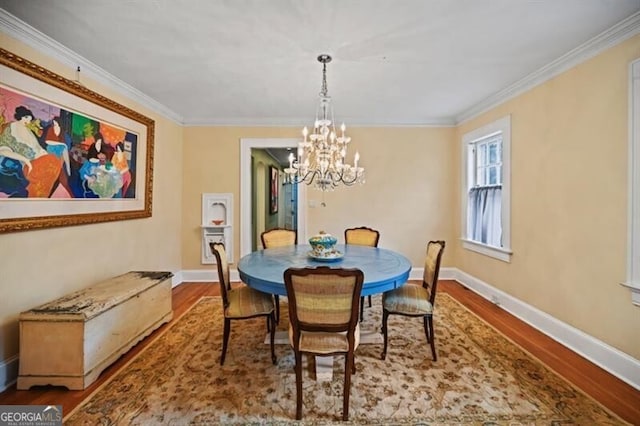 dining room with hardwood / wood-style flooring, ornamental molding, and a notable chandelier