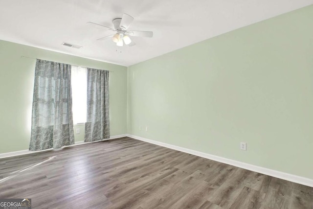 spare room featuring wood-type flooring and ceiling fan