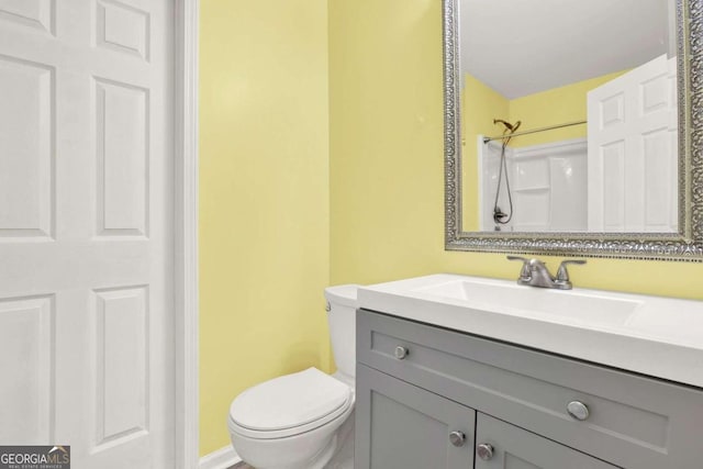 bathroom with a shower, vanity, and toilet