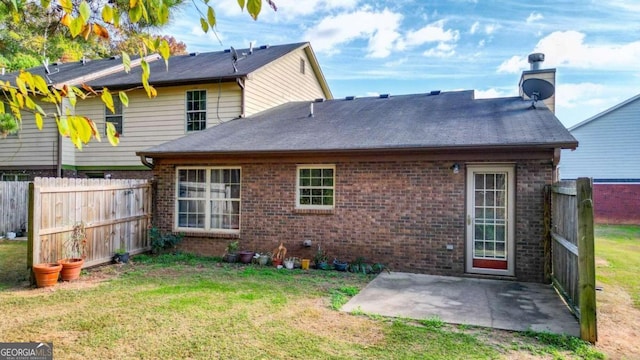 back of house with a lawn and a patio area