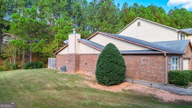 view of side of property with central AC and a yard