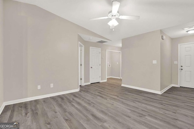 empty room featuring lofted ceiling, hardwood / wood-style flooring, and ceiling fan