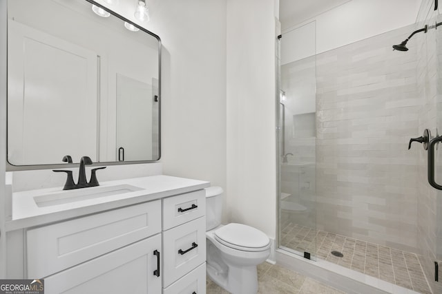 bathroom with vanity, tile patterned floors, toilet, and a shower with door