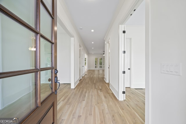 hall featuring ornamental molding, french doors, and light hardwood / wood-style floors