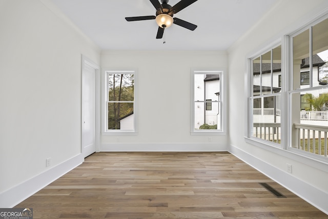 empty room with light hardwood / wood-style floors and ceiling fan