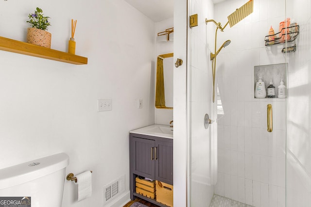 bathroom with vanity, a shower with shower door, and toilet