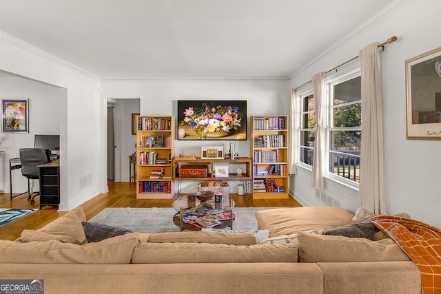 living room featuring light wood-type flooring and ornamental molding