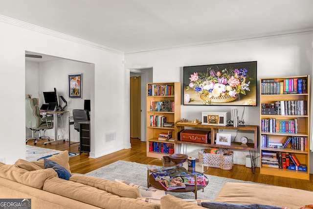 sitting room featuring wood-type flooring and ornamental molding