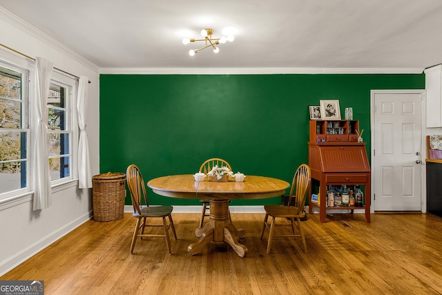 dining area with ornamental molding, light hardwood / wood-style flooring, a healthy amount of sunlight, and a notable chandelier