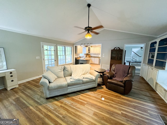 living room featuring ornamental molding, hardwood / wood-style floors, vaulted ceiling, and ceiling fan