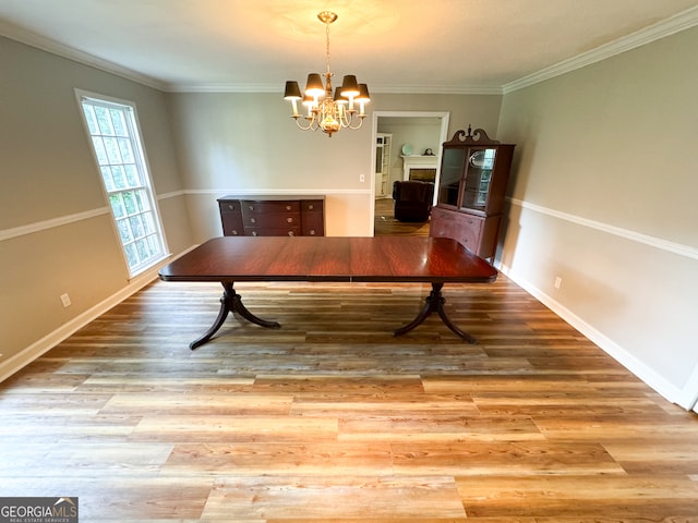 unfurnished dining area featuring light wood-type flooring, a chandelier, and ornamental molding