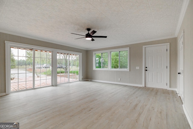 unfurnished living room with ceiling fan, plenty of natural light, crown molding, and light wood-type flooring