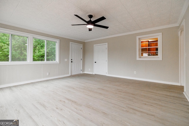 empty room with ceiling fan, ornamental molding, and light hardwood / wood-style flooring