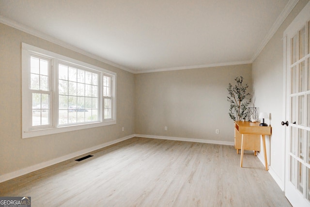 empty room featuring crown molding and light hardwood / wood-style floors