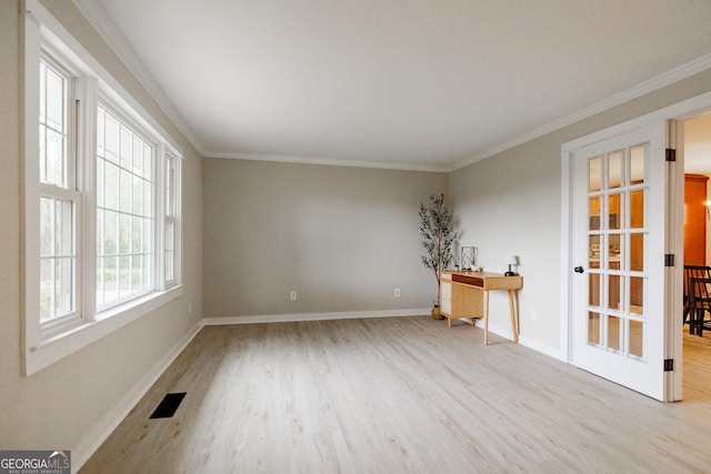 spare room featuring ornamental molding and light hardwood / wood-style flooring